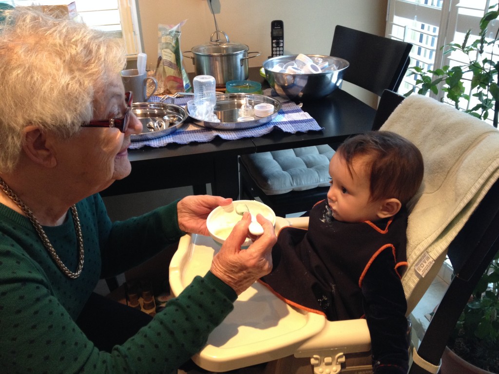 My son at 8 months eating yogurt and fruit with his Great-Grandma June