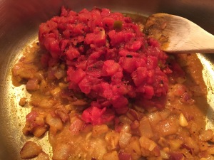 Adding tomatoes to nine vegetable curry for toddlers