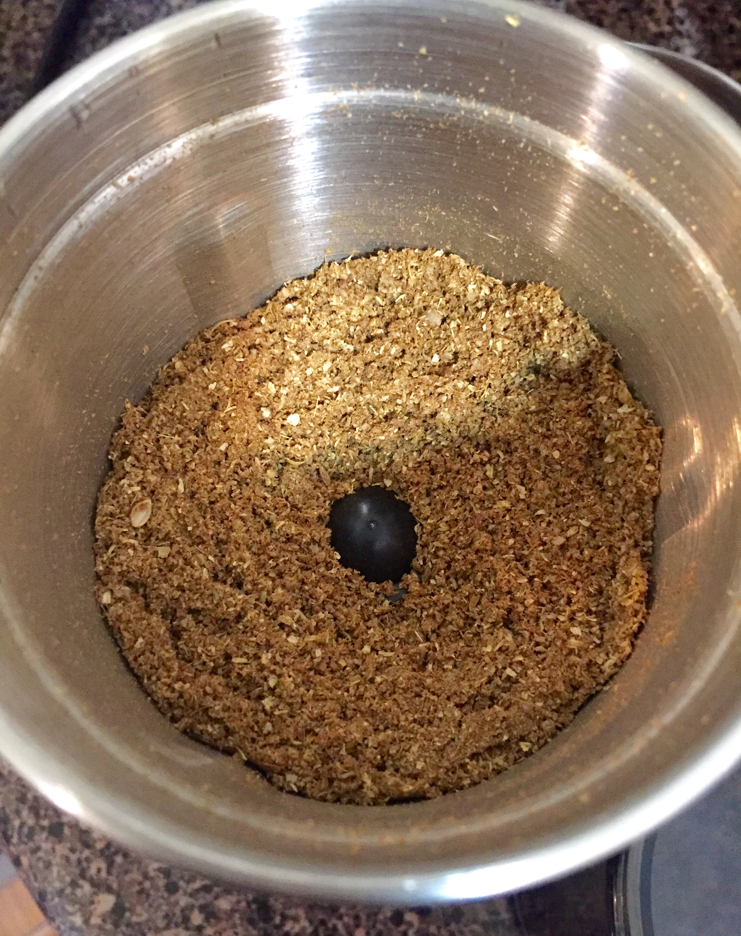 Grinding roasted coriander and cumin seeds