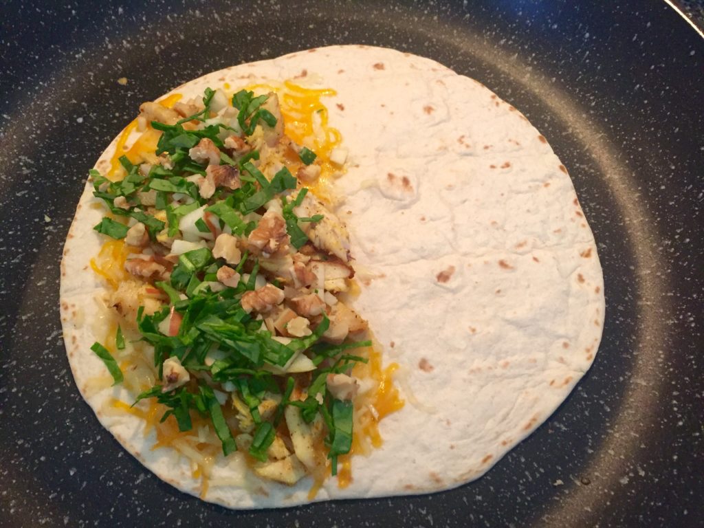 Add baby spinach and walnuts to quesadilla